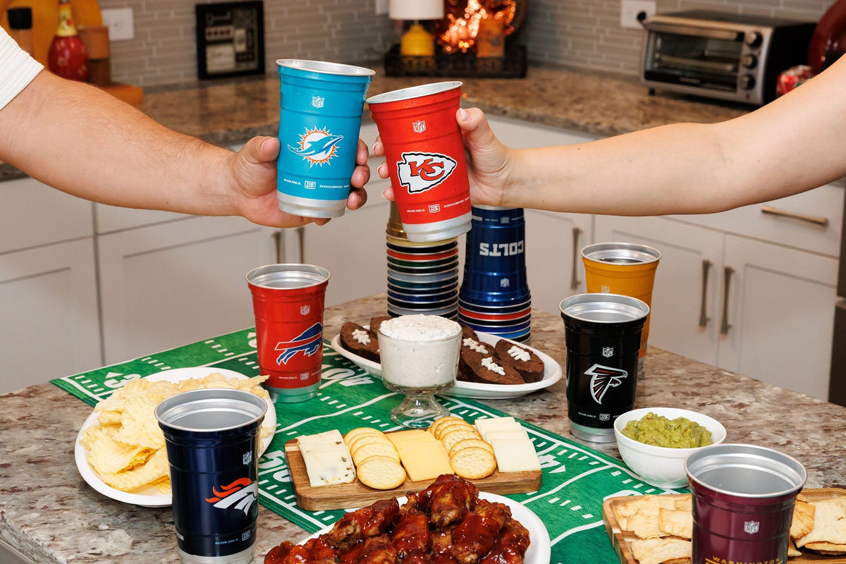 Friends raising officially licensed NFL Top Cup aluminum cups at a game day watch party